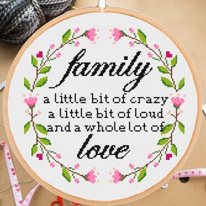May include: A white embroidery hoop with a floral design and the text "family a little bit of crazy a little bit of loud and a whole lot of love".