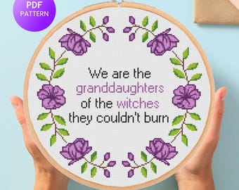 May include: A cross-stitch embroidery hoop with the text "We are the granddaughters of the witches they couldn't burn." The design features purple flowers and green leaves. A purple circle with "PDF PATTERN" is in the upper left.