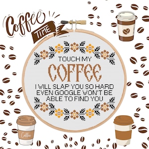 Pode incluir: Um aro de bordado branco com uma moldura de madeira marrom. O aro apresenta um design de ponto cruz com uma borda floral e o texto "Touch My Coffee I Will Slap You So Hard Even Google Won't Be Able To Find You".