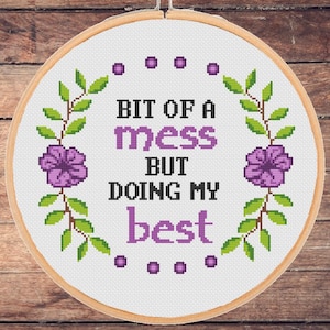 Könnte beinhalten: Weißer Stickrahmen mit einem violetten Blumendesign und dem Text "Bit of a mess but doing my best".