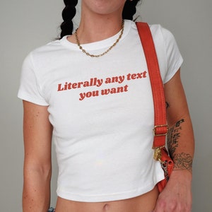 Puede incluir: Camiseta blanca recortada con el texto "Literally any text you want" en rojo.