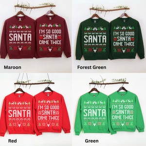K&ouml;nnte beinhalten: Vier Weihnachtspullover in den Farben Bordeaux, Tannengr&uuml;n, Rot und Gr&uuml;n. Jeder Pullover hat das Wort "SANTA" und den Satz "I'M SO GOOD SANTA CAME TWICE" in einem festlichen Design. Die Pullover werden auf Kleiderb&uuml;geln pr&auml;sentiert.
