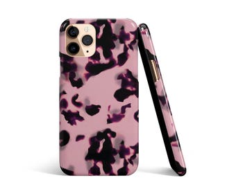May include: Two phone cases with a pink and black tortoiseshell pattern. One case is upright, and the other is leaning against it. The cases have a glossy finish and a black border.