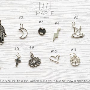 May include: A collection of twelve silver-toned metal charms labelled #1 through #12, including a hamsa, crescent moon, lightning bolt, bird, feather, horseshoe, cross, lotus, heart, tree, and paw print. Text states charms range from 0.6 cm to 1.3 cm.