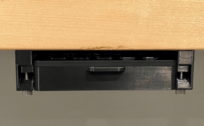 May include: A black under-desk drawer with a handle and a wood top.