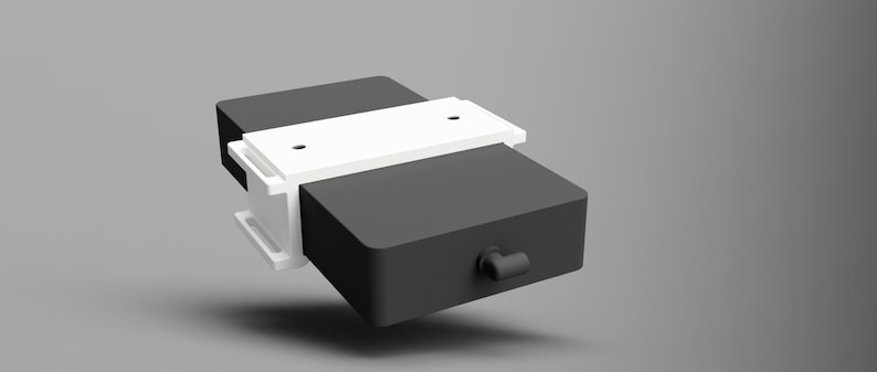 May include: A black rectangular box with a white plastic clamp on top. The box has a small black handle on the side.