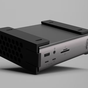 K&ouml;nnte beinhalten: Ein silbernes und schwarzes Computergeh&auml;use mit mehreren Anschl&uuml;ssen und einem wabenf&ouml;rmigen L&uuml;ftungsdesign. Das Geh&auml;use hat zwei schwarze Halterungen oben und der Markenname "ColdCraft" ist auf der Seite sichtbar.