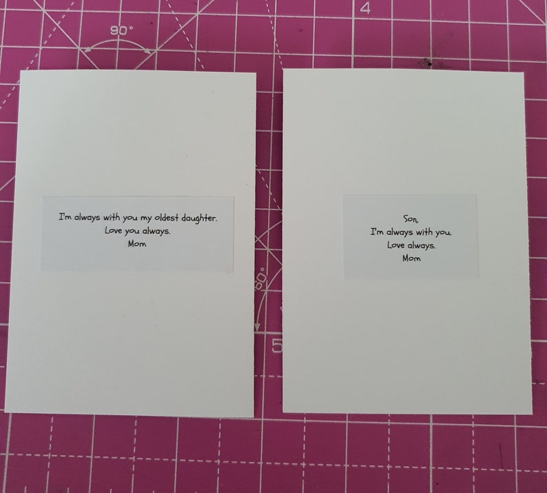 Puede incluir: Dos tarjetas de felicitaci&oacute;n blancas con texto. Una tarjeta dice: "Siempre estoy contigo, mi hija mayor. Te amo siempre. Mam&aacute;." La otra tarjeta dice: "Hijo, siempre estoy contigo. Te amo siempre. Mam&aacute;."