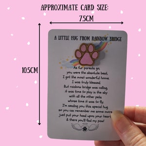 Puede incluir: Una tarjeta con el texto "A Little Hug From Rainbow Bridge" y un dise&ntilde;o de huella de pata. La tarjeta mide aproximadamente 7,5 cm de ancho y 10,5 cm de alto. La tarjeta incluye un poema sobre una mascota.