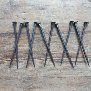 Set aus 5 handgeschmiedeten 18 cm langen Nägeln Alte, handgefertigte Schmiedenägel Seltene quadratische Eisennägel 10 flache Nägel