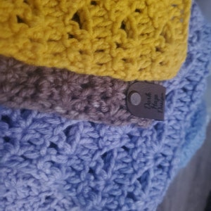 May include: A multi-colored crocheted scarf with a brown leather tag that says "Park Place Designs".