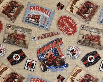 May include: Fabric with a repeating pattern of vintage Farmall tractor designs and logos in red, blue, and white. The fabric includes text such as "Farmall" and "International Harvester".