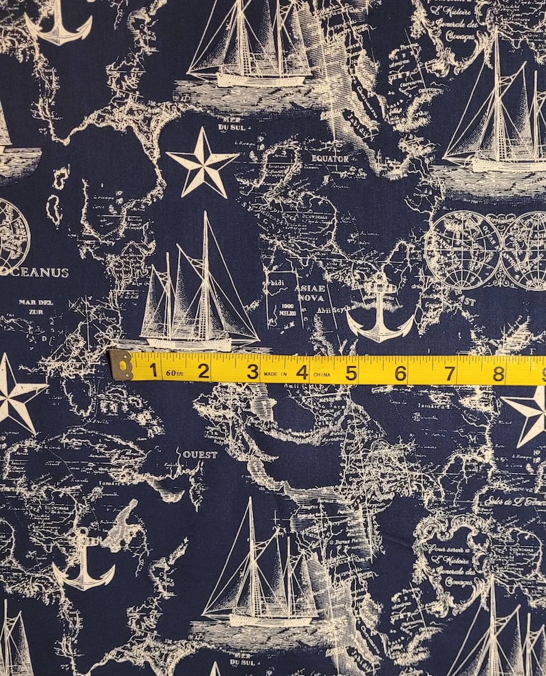 May include: A navy blue fabric with a white nautical map pattern. The map features ships, anchors, stars, and text including "OCEANUS", "MAR DEL ZUR", "ASIAE NOVA", "EQUATOR", and "QUEST".