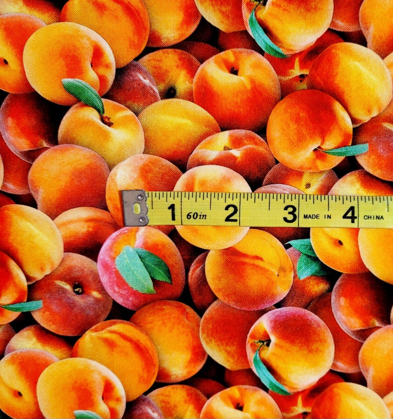 May include: A close-up of a fabric with a repeating pattern of peaches. The fabric is a peach color with a yellow tape measure across the middle. The tape measure reads "1 60in 2 3 MADE IN 4 CHINA".