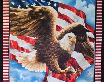 May include: A bald eagle with outstretched wings soars in front of a waving American flag against a blue sky with white clouds.