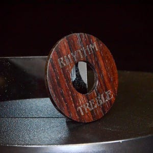 May include: A wooden knob with a hole in the centre. The knob is engraved with the words "Rhythm" and "Treble".