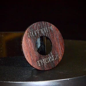 May include: A wooden knob with a round hole in the center. The knob is engraved with the words "Rhythm" and "Treble".