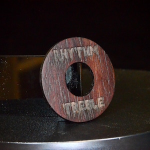 May include: A wooden knob with the words "Rhythm Treble" engraved on it. The knob is brown and has a hole in the centre.