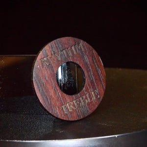 May include: A wooden knob with a round hole in the centre. The knob is engraved with the words "Rhythm" and "Treble".