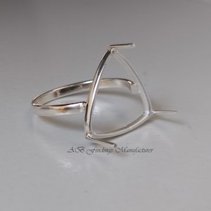May include: Silver ring setting with a triangular bezel for a gemstone. The ring is designed to hold a triangular shaped stone.
