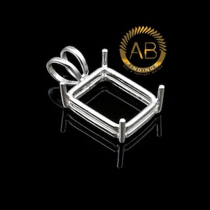 Puede incluir: Un engaste de colgante rectangular plateado con cuatro garras y un lazo para una cadena. El engaste está diseñado para sostener una piedra preciosa. El logotipo "AB FINDINGS GET A PERFECT MATCH" está en la esquina superior derecha.