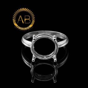 May include: A silver ring setting with a round bezel and four prongs. The ring is displayed on a reflective black surface. The logo "AB FINDINGS GET A PERFECT MATCH" is in the upper left corner.