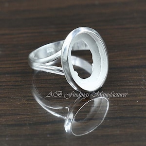 Puede incluir: Engaste de anillo de plata con un bisel de forma ovalada para una piedra. El anillo tiene un diseño delicado y calado en la banda.