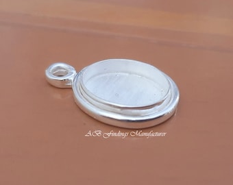 Peut inclure: Pendentif ovale en argent avec un sertissage pour une pierre en cabochon. Le pendentif a une boucle pour attacher une chaîne ou un cordon.