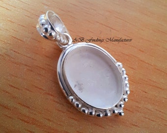 Può includere: Ciondolo in argento con un'apertura rotonda a bezel per una pietra o un cammeo. Il ciondolo ha un bordo perlato e un anello in alto per attaccare una catena.