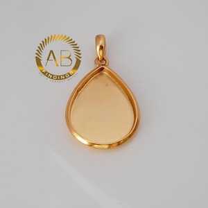 May include: A gold-coloured teardrop pendant with a loop at the top for a chain. The pendant has a smooth, polished finish and a recessed area for a design. The logo "AB FINDINGS GET A PERFECT MATCH" is in the upper left.