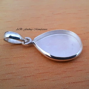Op de afbeelding: Zilveren hangerbezetting met een traanvormige bezel, klaar om te worden gevuld met een steen of andere versiering. De hanger heeft een lus om aan een ketting of koord te bevestigen.