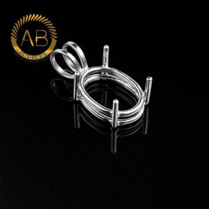 May include: A silver-colored metal pendant setting featuring an oval-shaped frame with four vertical prongs designed to hold a gemstone. The setting includes a rounded bail at the top for attachment to a chain, with a polished finish.