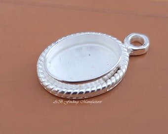 Peut inclure: Pendentif ovale en argent avec un bord en corde et une boucle pour l'accrocher. Le pendentif est conçu pour contenir un cabochon.