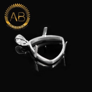 Può includere: Un castone per ciondolo color argento con un design triangolare, con griffe per fissare una gemma. Il castone include un anello per una catena ed è mostrato su uno sfondo nero. Il logo "AB FINDINGS GET A PERFECT MATCH" si trova in alto a sinistra.