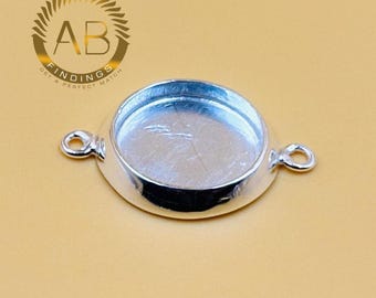 May include: A silver-colored, round jewelry finding with a recessed center and two loop attachments. The finding has a shiny, reflective surface and is designed for jewelry making. The logo "AB FINDINGS GET A PERFECT MATCH" is in the upper left corner.