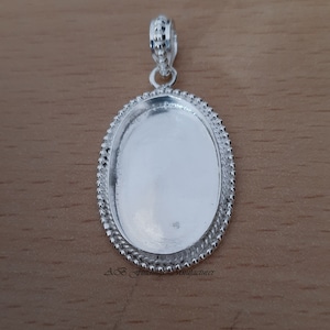 May include: Silver oval pendant with a beaded border. The pendant is blank and ready to be customized.