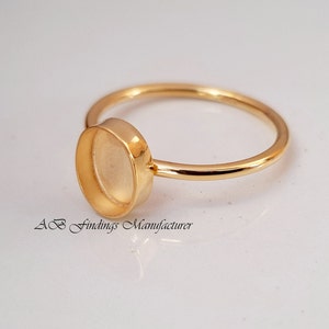 Könnte beinhalten: Goldring mit einer runden Fassung für einen Cabochonstein. Der Ring ist aus vergoldetem Metall gefertigt und kann mit Ihrem Lieblingsstein individuell gestaltet werden.