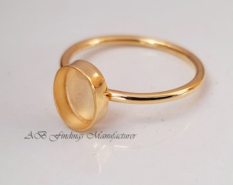 Può includere: Anello in oro con una montatura rotonda per una pietra a cabochon. L'anello è in metallo placcato oro ed è pronto per essere personalizzato con la tua pietra preferita.