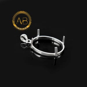 May include: A silver-colored oval pendant setting with four prongs and a loop for a chain. The setting is designed to hold a gemstone. The logo "AB FINDINGS GET A PERFECT MATCH" is in the upper left corner.