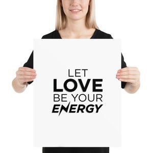 Puede incluir: Un p&oacute;ster blanco con texto negro que dice "Let Love Be Your Energy". El texto est&aacute; en negrita, sin serif. El p&oacute;ster est&aacute; siendo sostenido por una persona.