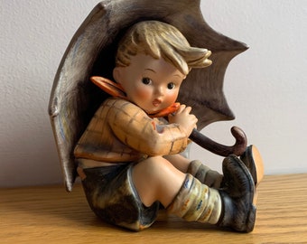 hummel boy walking with umbrella