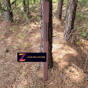 May include: A long, narrow, brown vertical object with a flat, rectangular top and a tapered bottom end. A darker brown rectangular panel with a series of small, evenly spaced holes is attached to the center. The text ZIYA COLLECTION is visible.