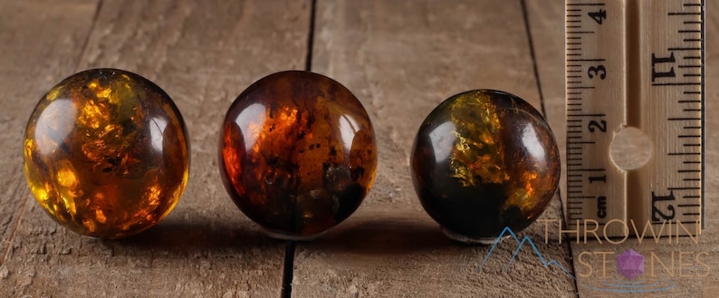 Genuine Amber Crystal Spheres. These semi precious orange crystal balls are between 15 and 40 millimeters in diameter and weigh between 1 and 40 grams. This listing has variations and only medium large and extra large spheres will come with a stand.