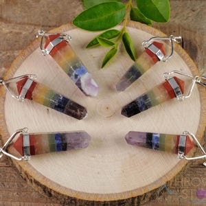These rainbow chakra crystal pendants are polished double terminated points held in a silver bail.  The points are a composite of different crystals.
Crystals are nature-made therefore each one is unique in appearance.