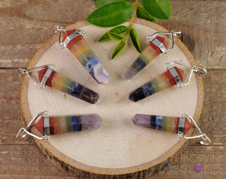 These rainbow chakra crystal pendants are polished double terminated points held in a silver bail.  The points are a composite of different crystals.
Crystals are nature-made therefore each one is unique in appearance.