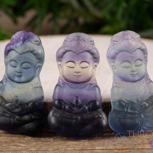 These rainbow Fluorite crystal pendants are carved in the shape of seated Buddha, with a small hole drilled.  Rainbow Fluorite is striated in sheer green, teal, and purple.
Crystals are nature-made therefore each one is unique in appearance.