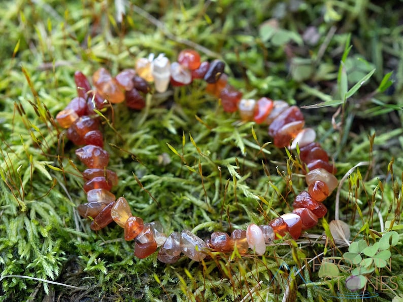Carnelian chip bracelet. These tumbled chips range in color from orange to red, are drilled and strung on an elastic cord, and create an endless bracelet.