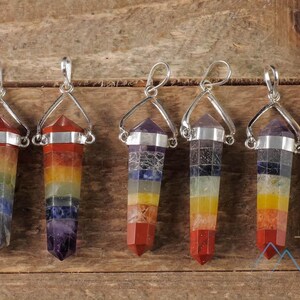 These rainbow chakra crystal pendants are polished double terminated points held in a silver bail.  The points are a composite of different crystals.
Crystals are nature-made therefore each one is unique in appearance.