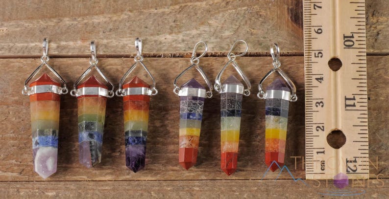These rainbow chakra crystal pendants are polished double terminated points held in a silver bail.  The points are a composite of different crystals.
Crystals are nature-made therefore each one is unique in appearance.