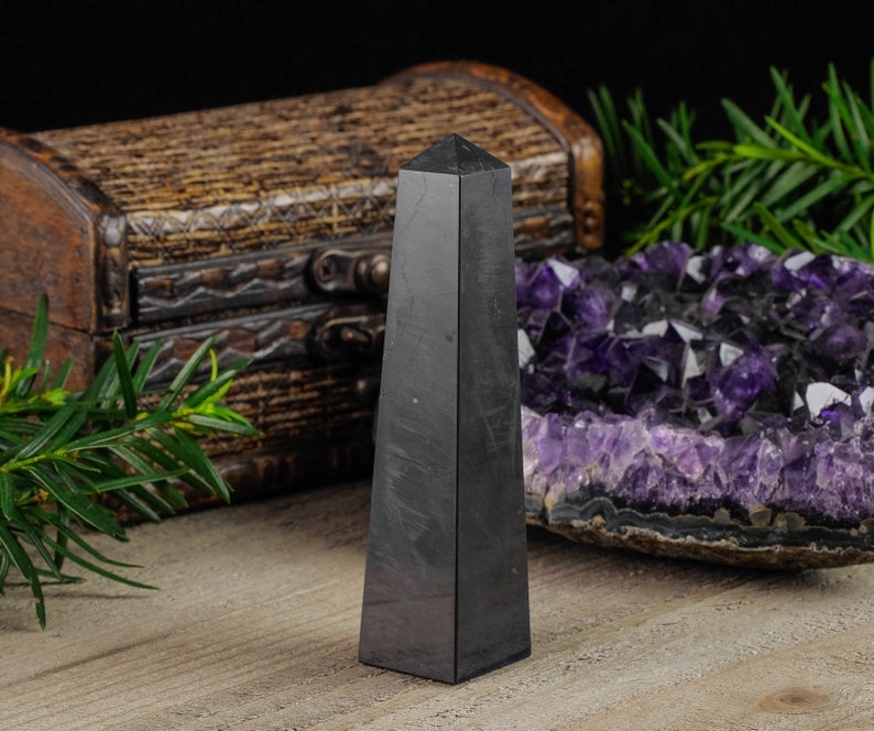 Shungite Crystal Tower. These genuine obelisk shaped crystal carvings are black with a polished finish and are great for crystal grids and decor. Each faceted crystal point is unique and will vary in size, shape, and color. Listing has variations.